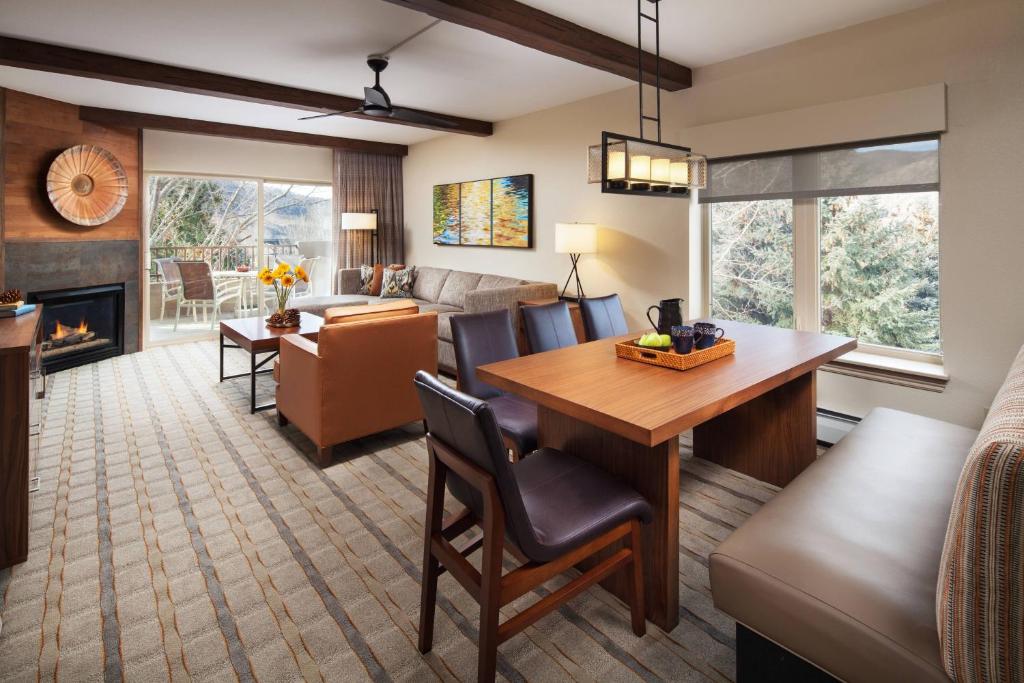 埃文Sheraton Lakeside Terrace Villas at Mountain Vista, Avon, Vail Valley的客厅和用餐室配有餐桌和壁炉