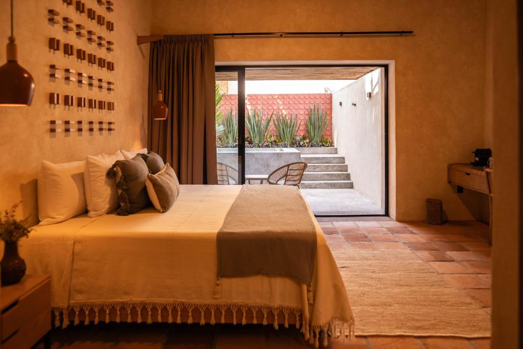 ComalaLa Paranera Hotel & Relax的一间卧室设有一张床,并有通往庭院的门