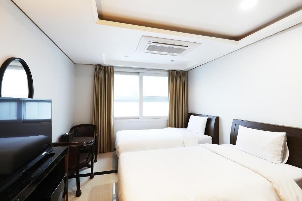 首尔城际首尔酒店 的酒店客房配有两张床和一张书桌