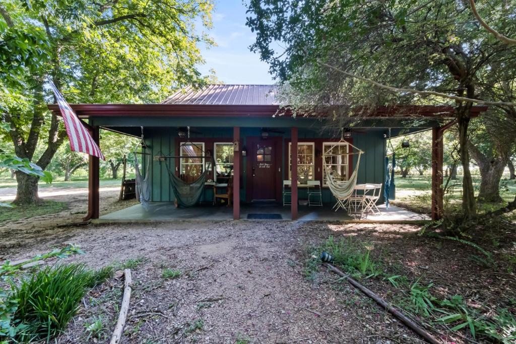 MaxwellBird House Countryside Pecan Farm 14acre San Marcos的一座带美国国旗的绿色小房子