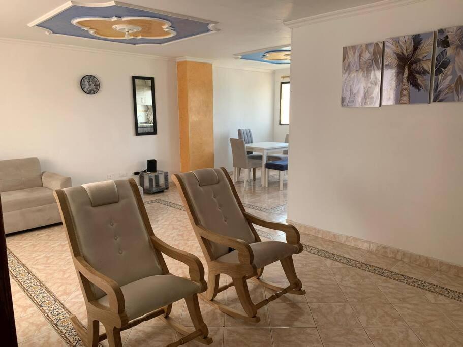卡塔赫纳Apartamento en Cartagena cerca del aeropuerto的客厅配有两把椅子和一张沙发