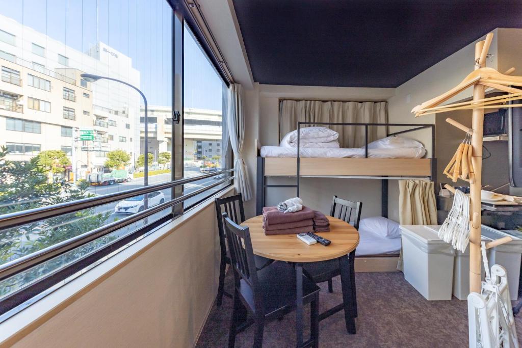 东京HOTEL HARE BARE 3min walk from Kiba Station的客房设有桌子和带双层床的阳台。