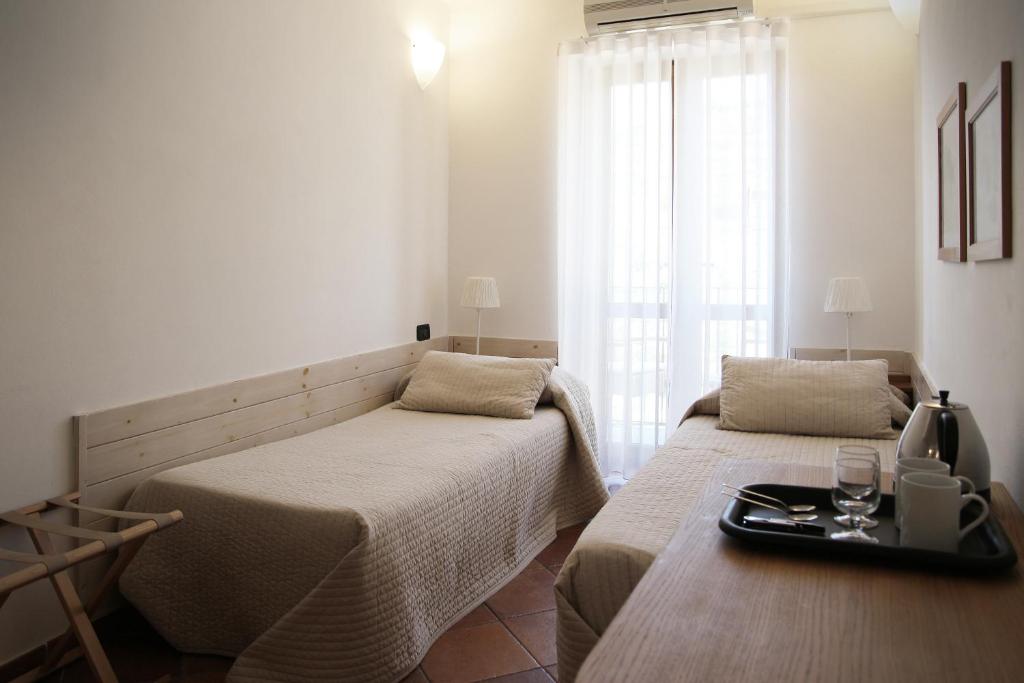马纳罗拉Da Baranin B&B的客房设有两张床和一张带托盘的桌子。
