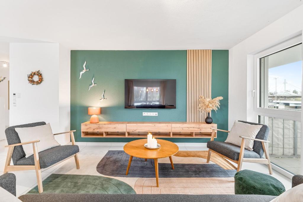莱因费尔登-埃希特尔丁根Design-Apartment - Küche - Parken - zentral的客厅配有电视、2把椅子和1张桌子