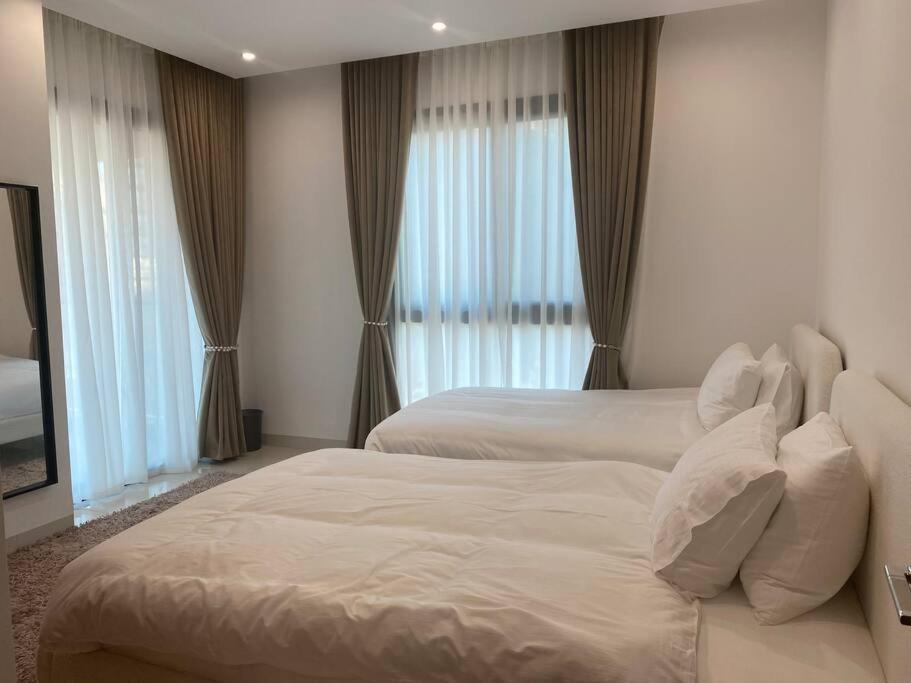 锡卜Beachfront 2BHK apartment at Al Mouj的酒店客房带两张床和窗户