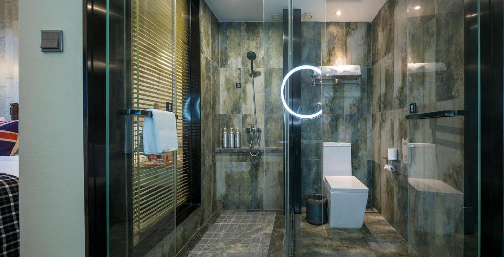 常州美豪酒店常州恐龙园旗舰店的一间带玻璃淋浴和卫生间的浴室