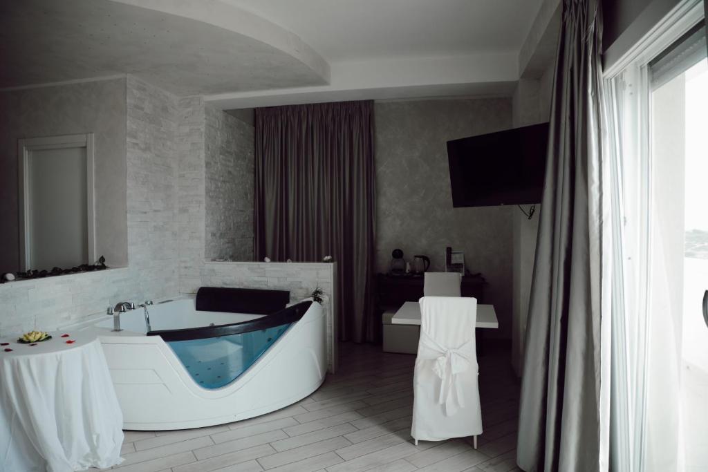 塔兰托蓝湾度假公寓的带浴缸的浴室和电视。