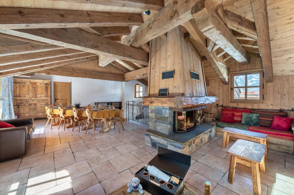 谷雪维尔Chalet K120 - Village du Praz - Courchevel的开放式客厅,位于房子内,设有壁炉