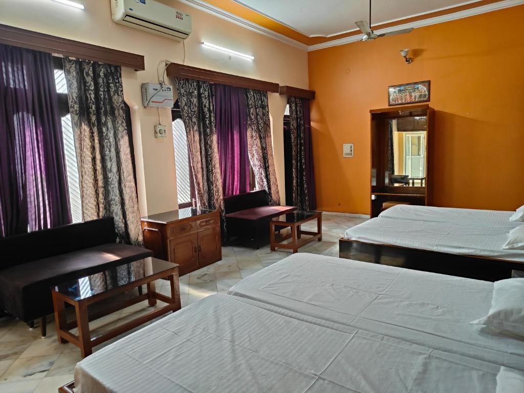 AyodhyaShantiniketan 4BHK Comfortable Family Stay in Ayodhya的酒店客房,配有两张床和椅子