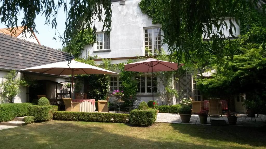 德平特威洛斯洛奇床和早餐的院子里有两把遮阳伞的房子