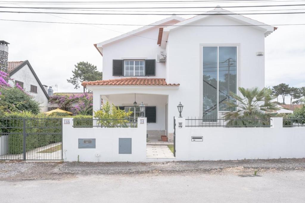 AroeiraNini's Beach House - Aroeira, Charneca da Caparica的白色的房子,有白色的围栏