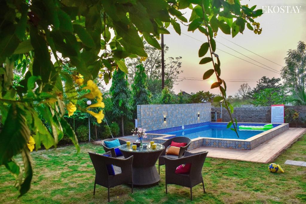卡尔贾特EKOSTAY- Nest Villa的一个带桌椅的花园和一个游泳池