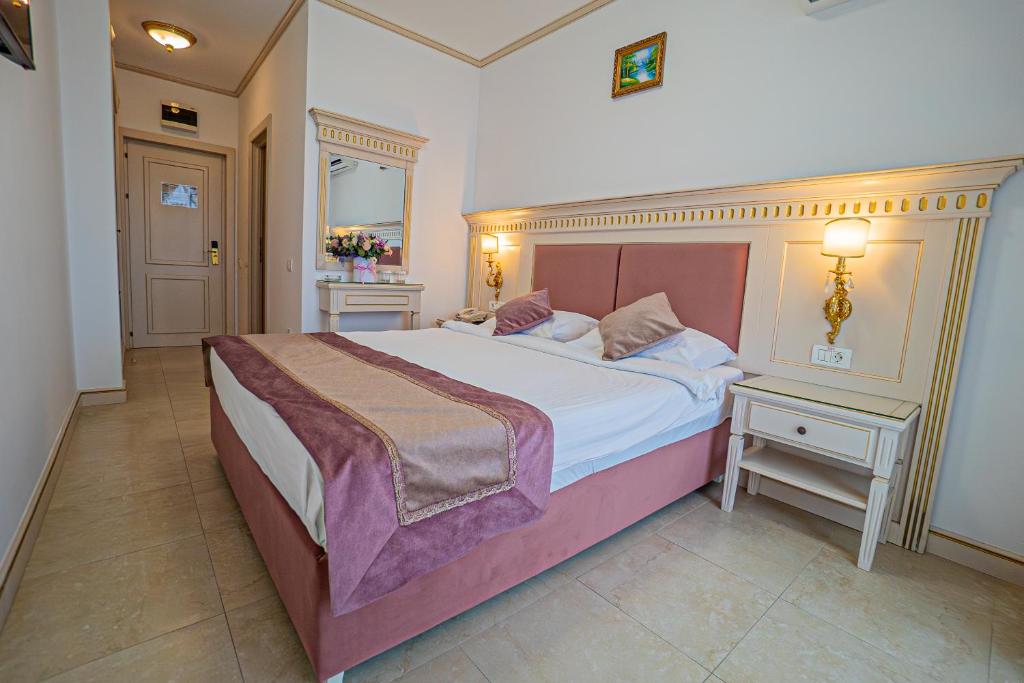 马马亚苏利纳国际酒店的一间卧室设有一张大床和两个床头柜