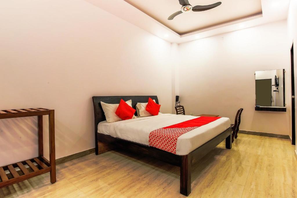 ChinhatVaibhav Laxmi Paradise的一间卧室配有一张带红色枕头和镜子的床