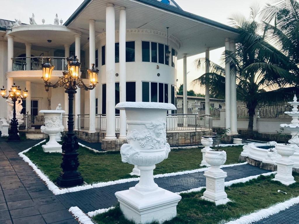 库马西The Peacock Mansion的前面有白色雕像的大建筑