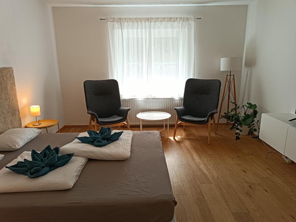 格拉茨Flataid Apartmenthaus Brauhausstrasse的客厅配有两把椅子和一张床