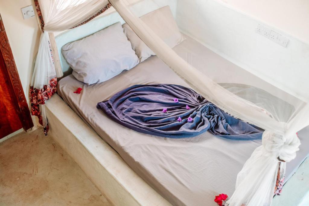 江比阿Marvelous Zanzibar的一张未铺床,上面有紫色毯子