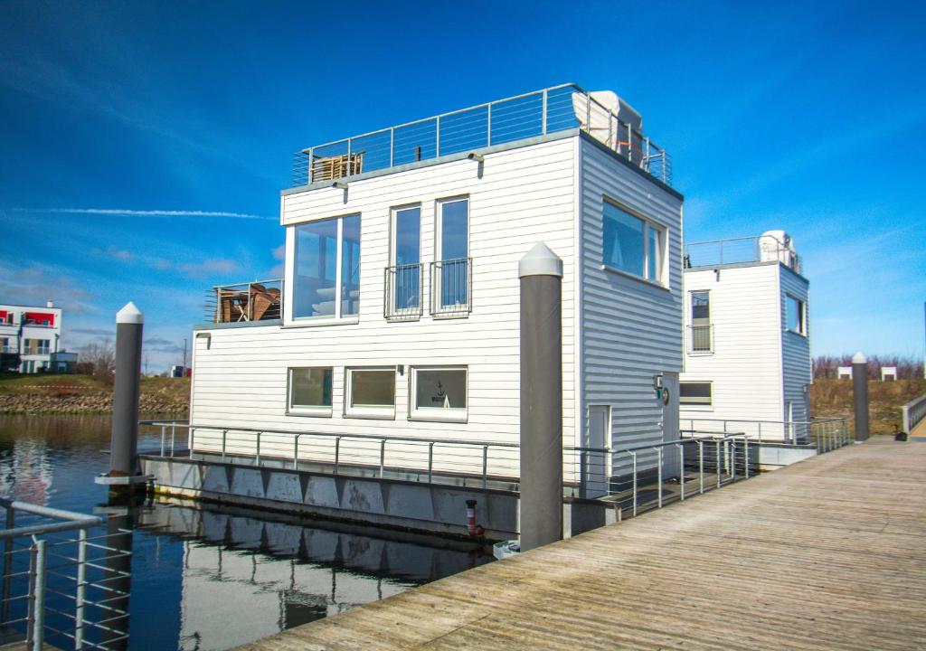 卡珀尔恩Schwimmendes Haus - An Bord Zwei的水面上码头上的白色房子
