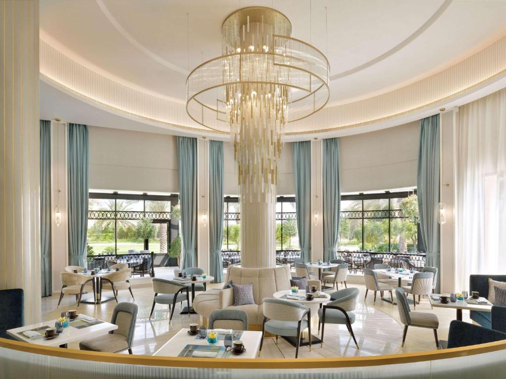 麦纳麦巴林瑞享酒店的一间带桌椅和吊灯的餐厅