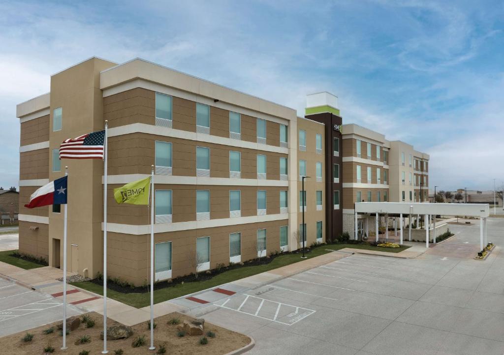 阿比林Home2 Suites By Hilton Abilene Southwest的前面有美国国旗的办公楼