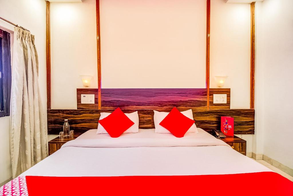 潘韦尔Super Collection O Hotel Panchratna的一间卧室配有一张带红色枕头的大床