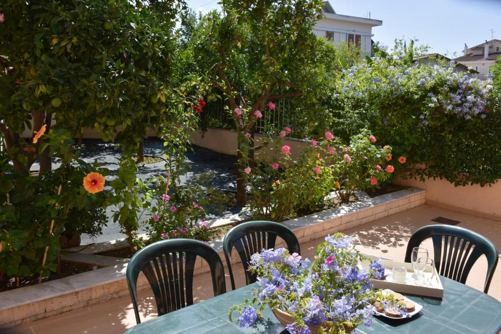 GastoúniKiki’s 3BD apt. with Citrus Garden & BBQ的花园里种满鲜花,配有桌椅