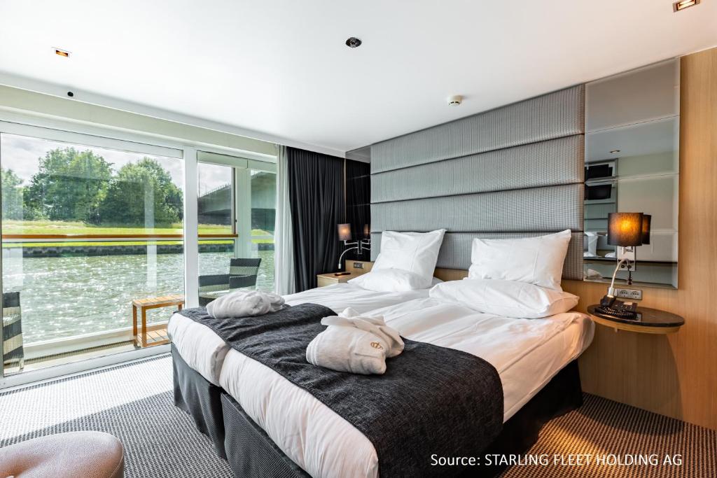 杜塞尔多夫KD Hotelship Düsseldorf Comfort Plus的酒店客房设有两张床和大窗户。