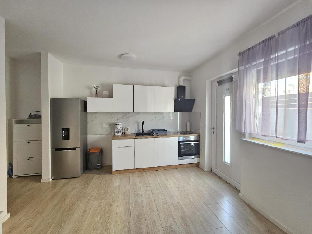 扎达尔Apartments Anamarija的厨房配有白色橱柜和台面