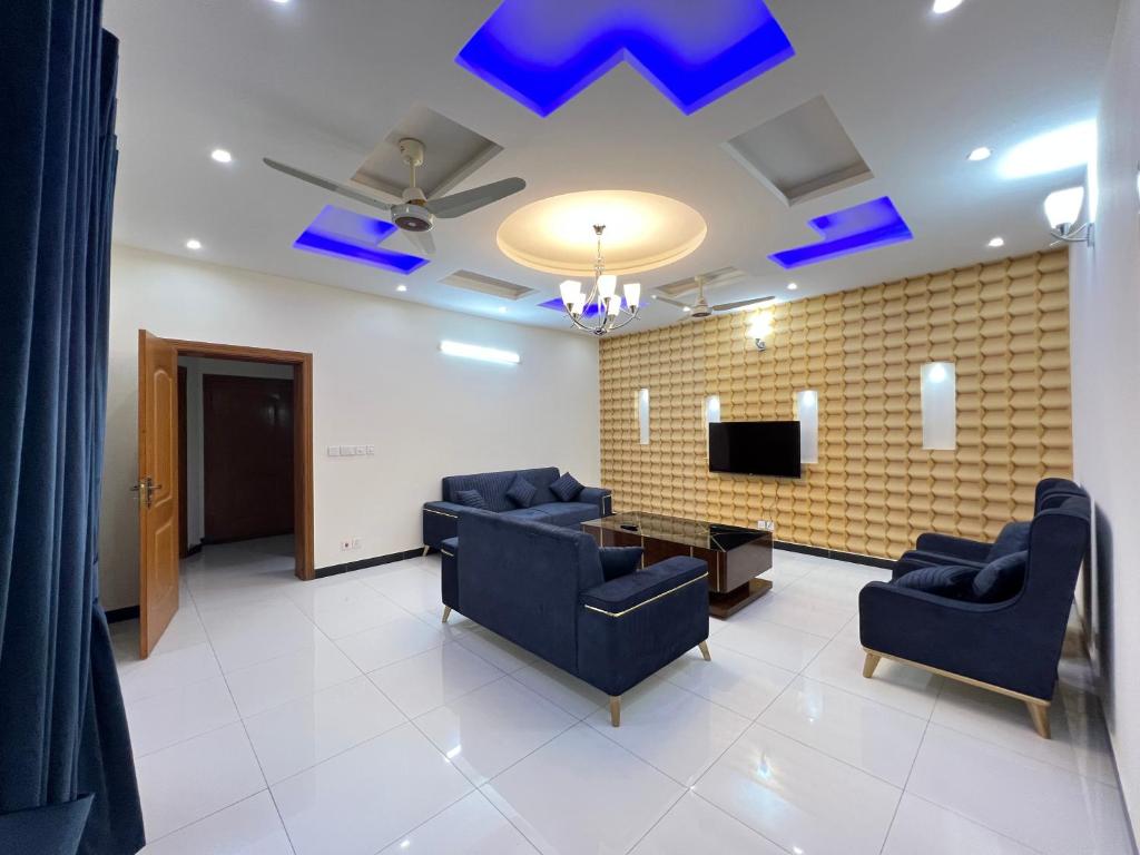 伊斯兰堡Luxury Villa in Islamabad Margala Hills Views的一间设有蓝色椅子和电视的等候室