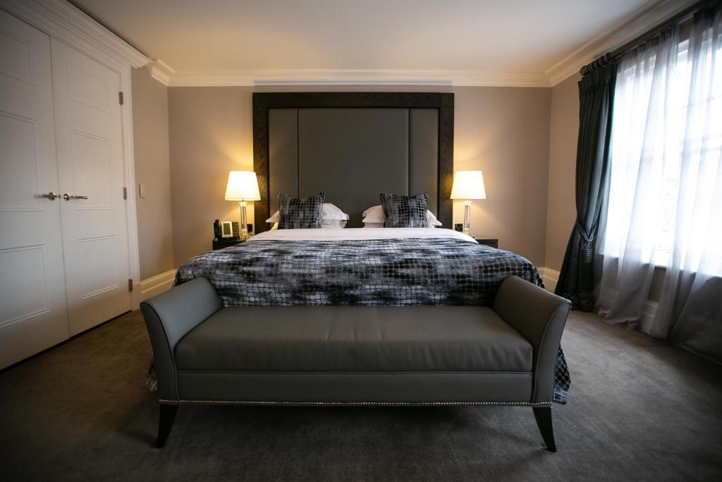皇家滕布里奇韦尔斯壹华威公园酒店的一间卧室配有一张沙发床和两盏灯。