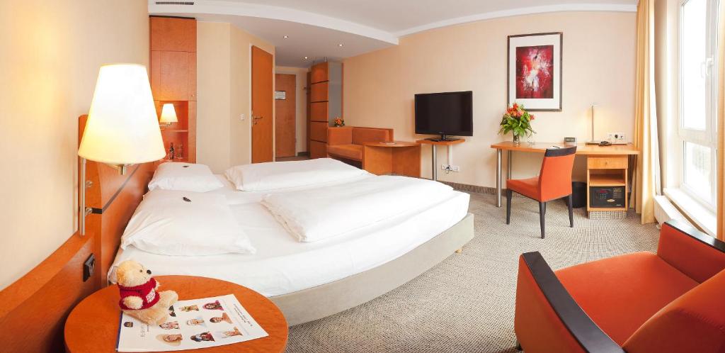 舍讷费尔德Best Western Premier Airporthotel Fontane BERlin的酒店客房设有一张白色大床和一张桌子。