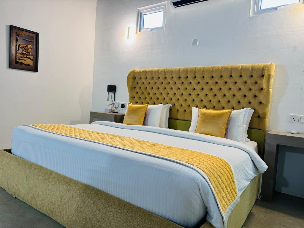 尼甘布ECO Hut by LEEL的一间卧室配有一张带黄色枕头的大床
