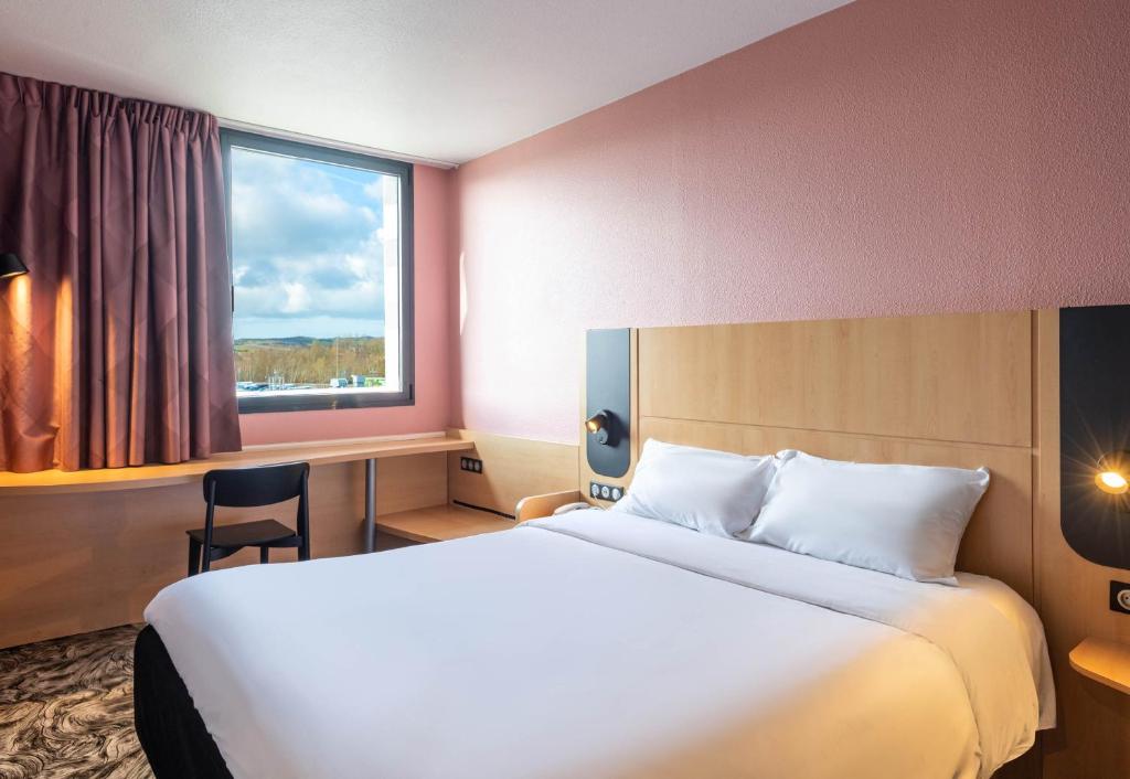 科凯勒B&B HOTEL Calais Terminal Cité Europe 3 étoiles的一间设有大床和窗户的酒店客房