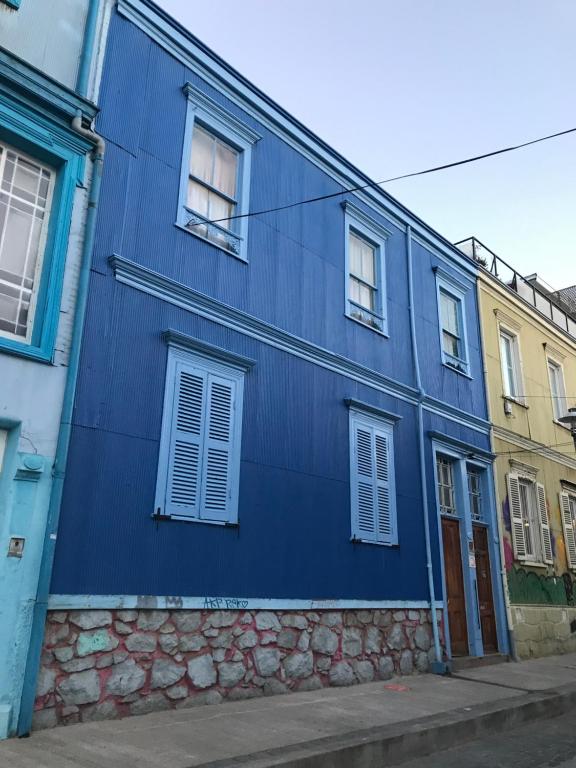瓦尔帕莱索B&B La Nona的蓝色的建筑,在街上有白色的窗户