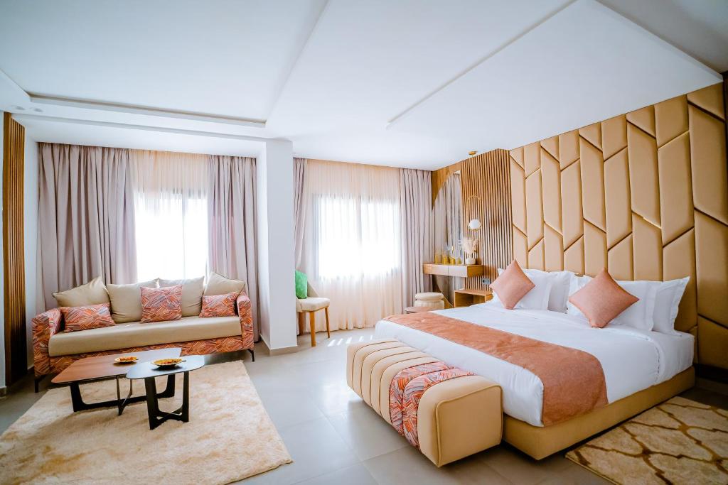 达赫拉TIMAZIN HOTEL DAKHLA的酒店客房设有一张大床和一张沙发。