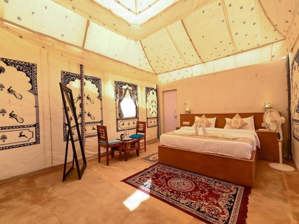 斋沙默尔Royal Luxury Camp Jaisalmer的卧室配有一张床和一张桌子