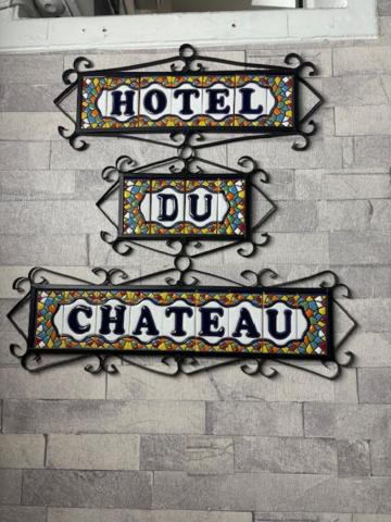 巴黎HOTEL DU CHATEAU的砖墙边的两处标志