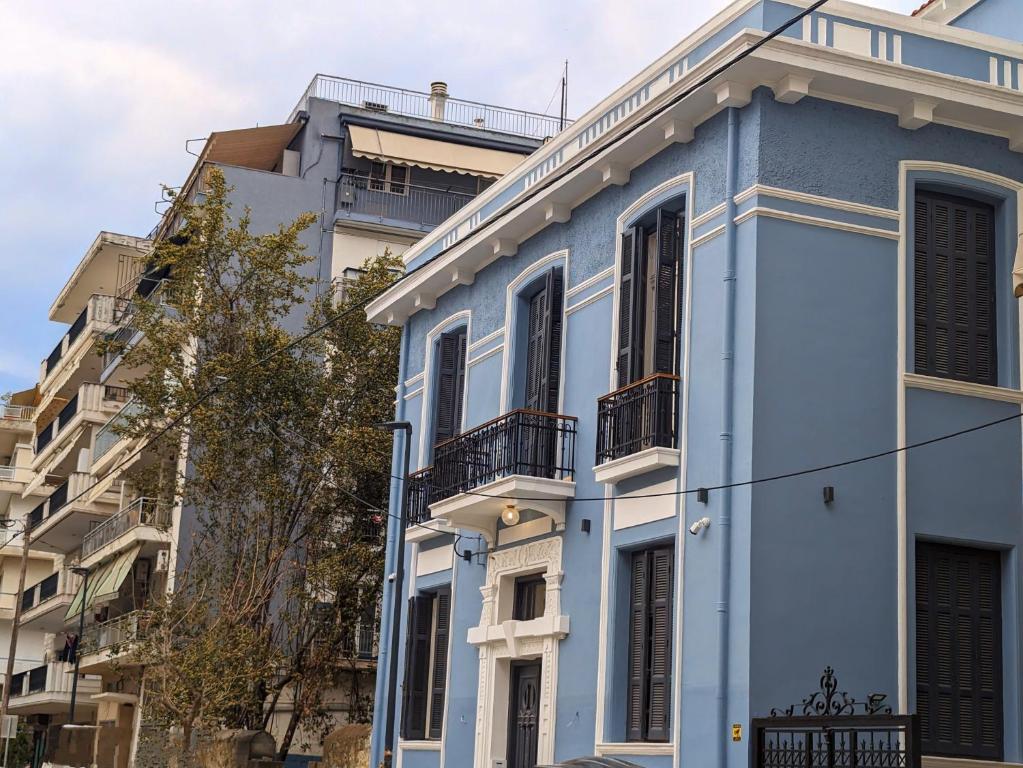 塞萨洛尼基Villa Clio, a Luxury Collection的蓝色房子,位于一些建筑前面