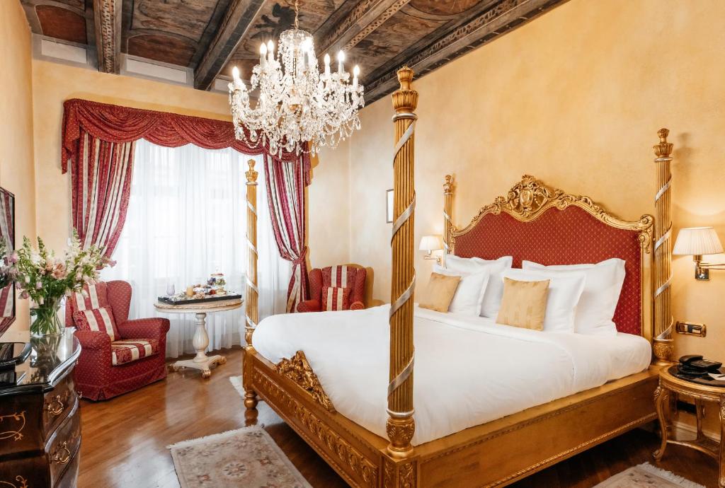 布拉格Alchymist Grand Hotel and Spa - Preferred Hotels & Resorts的一间卧室配有一张大床和一个吊灯。