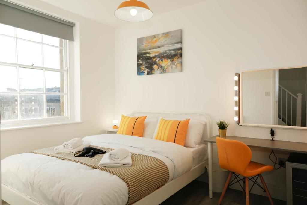 伦敦Camden Town Self Check-in Luxury Rooms的白色卧室设有床、书桌和窗户