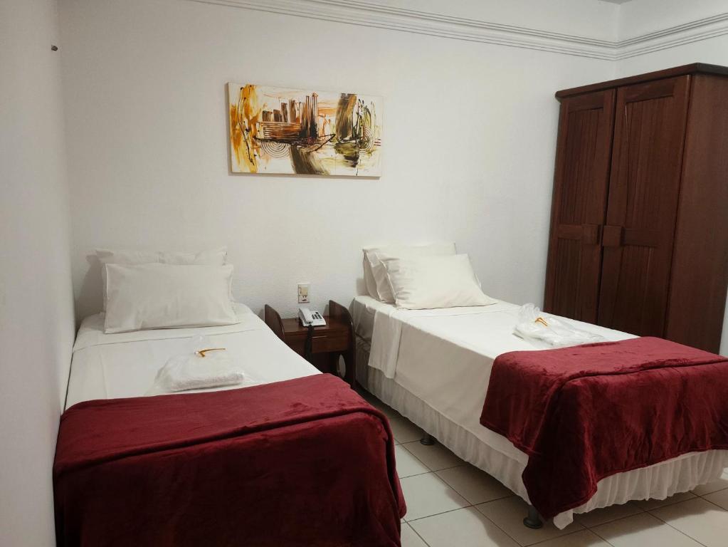 贝伦马查多广场酒店 的一间卧室设有两张床,墙上挂着一幅画