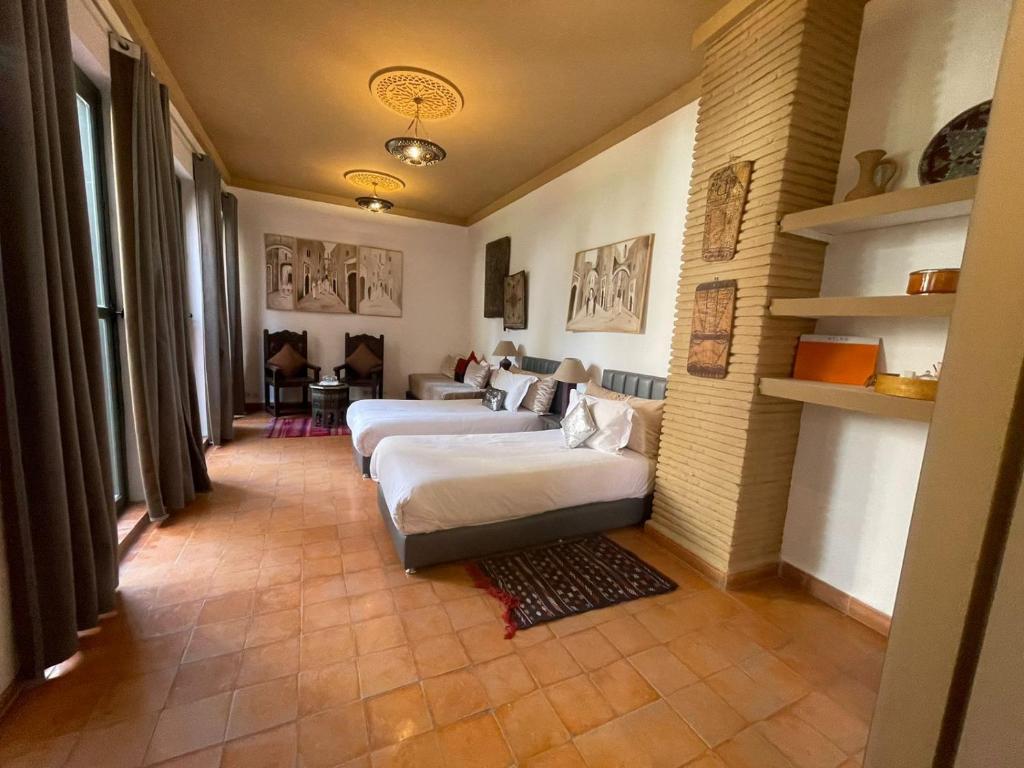 塔鲁丹特塔菲拉格摩洛哥传统庭院住宅的一间带两张床和一张沙发的客厅