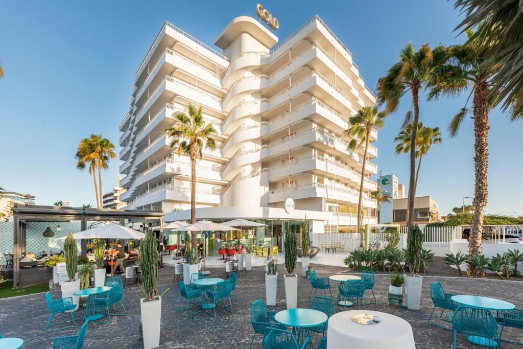 英格兰海滩Gold Playa del Ingles - Adults Only的 ⁇ 染酒店,拥有桌椅和棕榈树