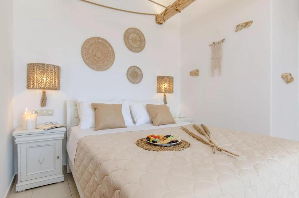 布拉卡Glaronissi Beach的一间白色的卧室,配有一张带一盘食物的床