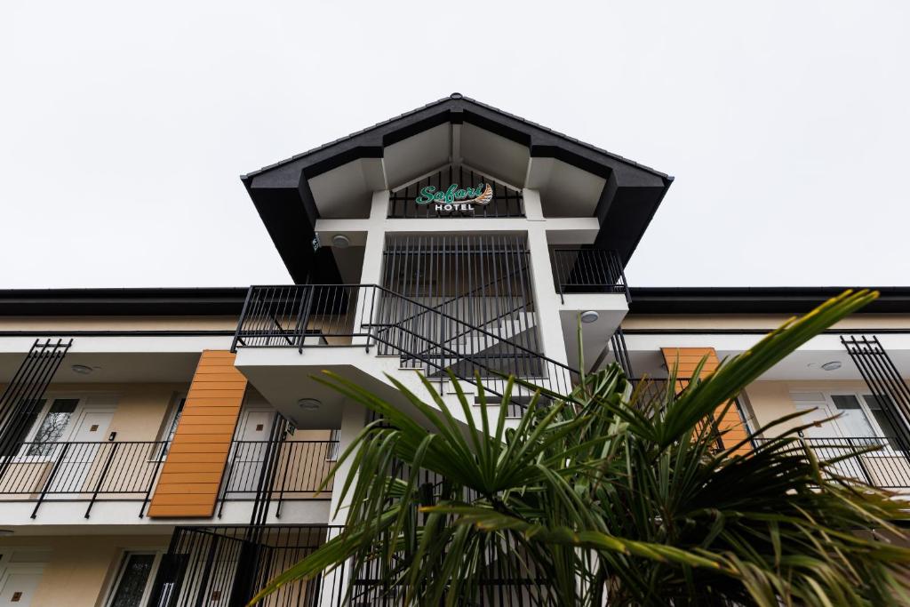 塞格德Safari Hotel的公寓大楼设有阳台和棕榈树