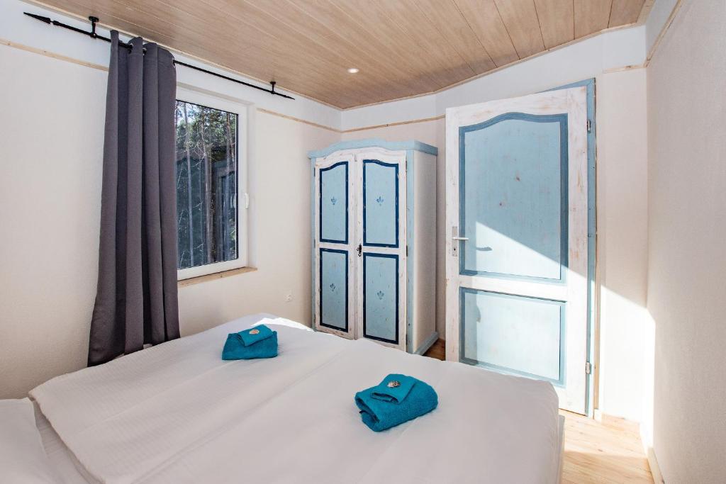 于克里茨Krebssee的一间卧室配有一张床,上面有2个蓝色拖鞋