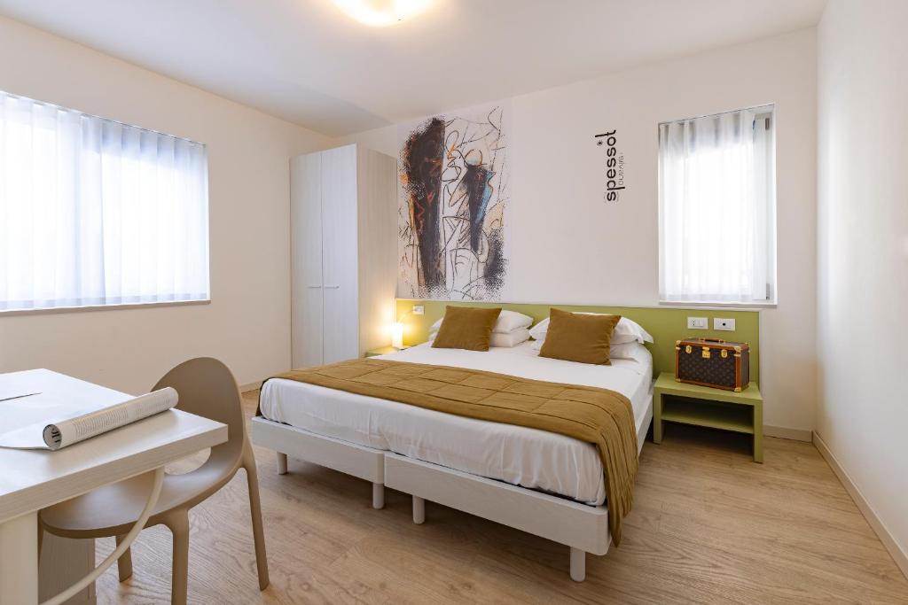 利尼亚诺萨比亚多罗Art Hotel Principe的卧室配有一张床、一张书桌和窗户。