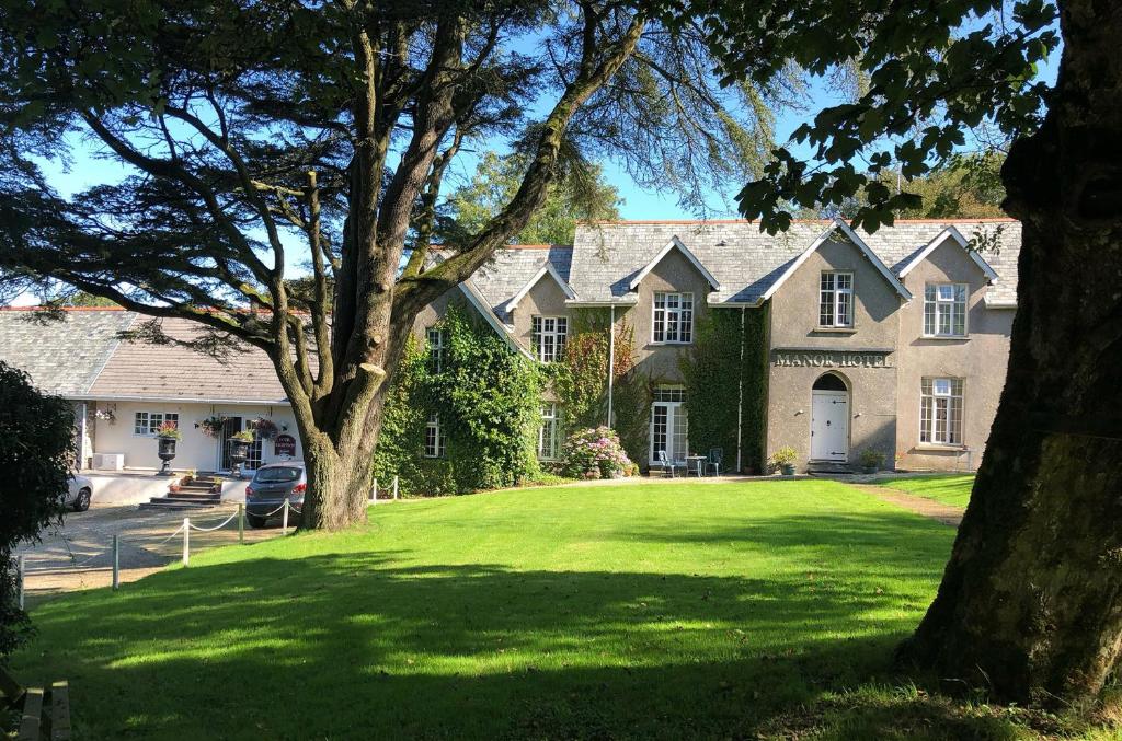 林顿Exmoor Manor Guest House的大型房屋,设有大型绿色草坪