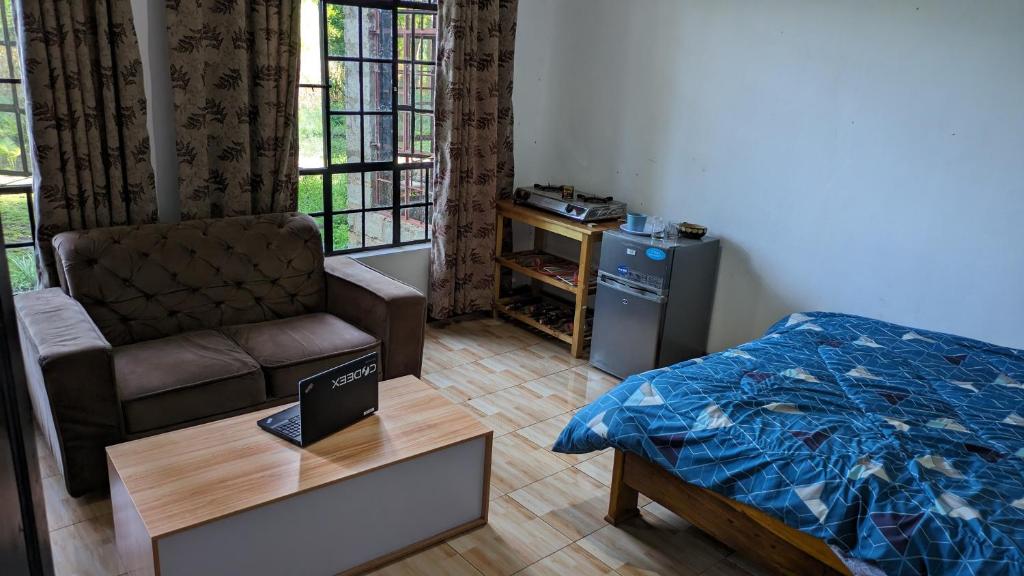 ShiriLala Homestay的一间卧室配有一张床、一张沙发和一张桌子