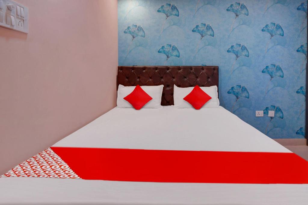 GulzārbāghSuper OYO Flagship Hotel Relax Rainbow的一张带红色枕头的床